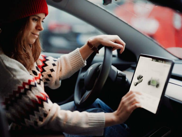 A woman using a Tesla touch screen